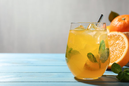 Delicious orange soda water on light blue wooden table. Space for textの写真素材