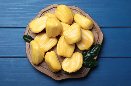 Delicious exotic jackfruit bulbs on blue wooden table, top viewの写真素材