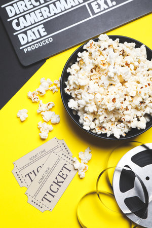 Flat lay composition with clapperboard, popcorn and tickets on color backgroundの写真素材