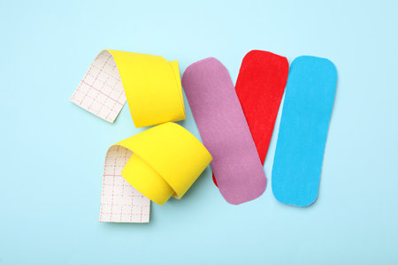 Bright kinesiology tape pieces on light blue background, flat layの写真素材