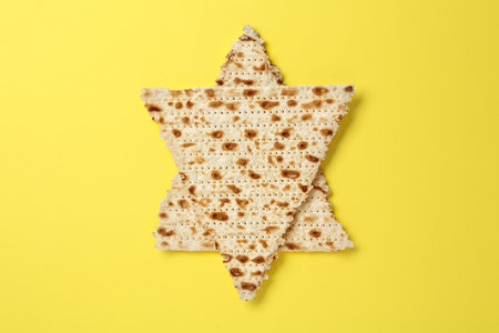 Star of David made with passover matzos on yellow background, top viewの写真素材