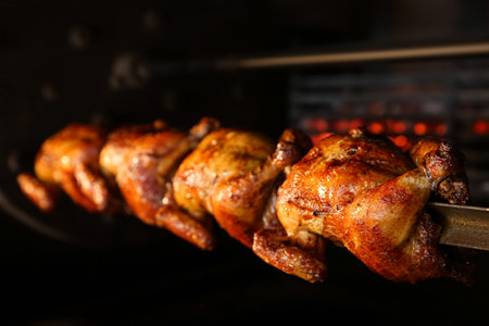 Grilling whole chickens in rotisserie machine, closeupの写真素材