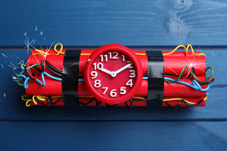 Dynamite time bomb on blue wooden table, top view