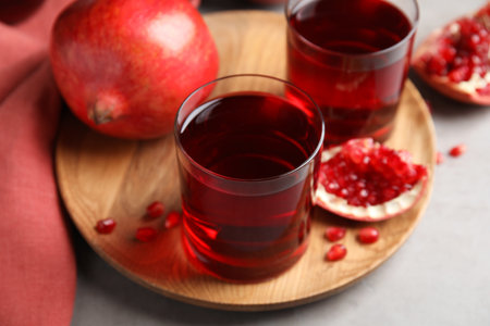 Pomegranate juice and fresh fruits on gray tableの写真素材