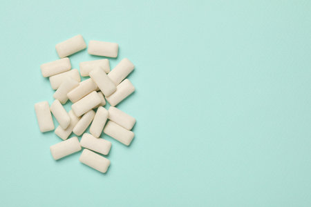 Many chewing gum pieces on turquoise background, flat lay. Space for textの写真素材