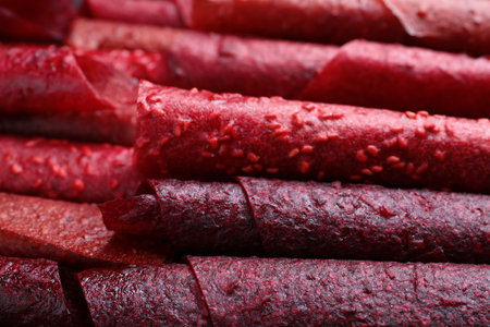 Delicious fruit leather rolls as background, closeupの写真素材