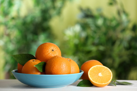 Fresh ripe oranges on white table against blurred background. Space for textの写真素材