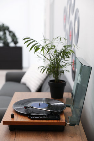 Stylish turntable with vinyl disc in living room