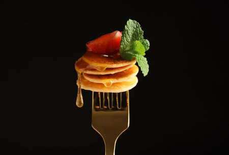 Fork with cereal pancakes, strawberry and mint on black backgroundの写真素材