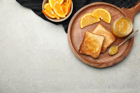 Delicious toasts with orange marmalade on light gray table, flat lay. Space for textの写真素材