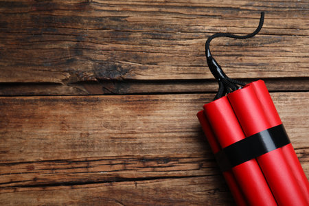 Red explosive dynamite bomb on wooden background, top view. Space for textの写真素材