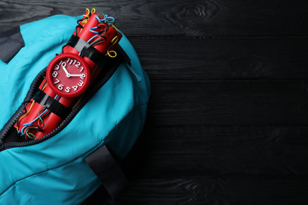 Blue sportive bag with dynamite time bomb on black wooden table, top view. Space for textの写真素材