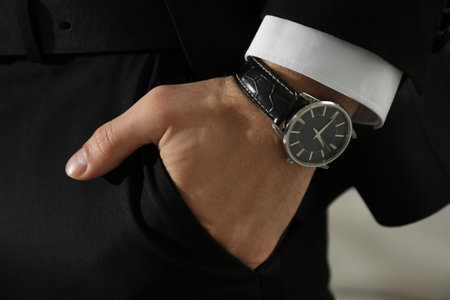 Businessman with luxury wrist watch on blurred background, closeup