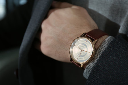 Man wearing luxury wrist watch with leather band, closeup