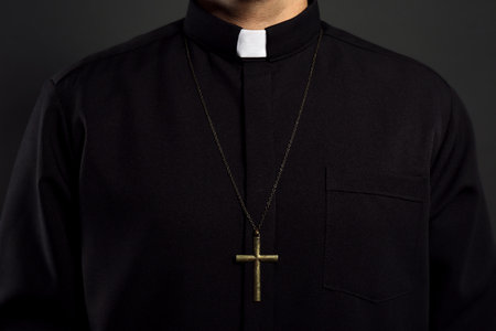 Priest with cross on black background, closeupの写真素材