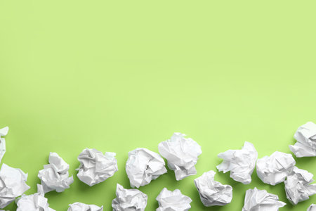 Crumpled sheets of paper on light green background, flat lay. Space for textの写真素材