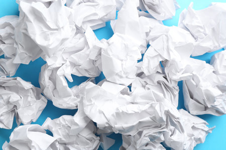Crumpled sheets of paper on light blue background, closeupの写真素材