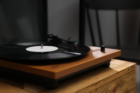 Stylish turntable with vinyl disc on wooden crate in room, closeupの写真素材