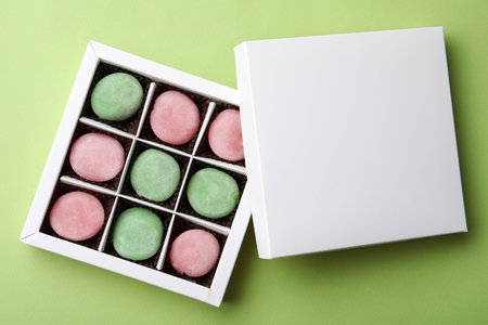 Many different delicious mochi in box on green background, top view. Traditional Japanese dessertの写真素材