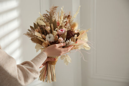Woman holding beautiful dried flower bouquet at home, closeupの写真素材