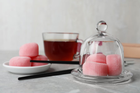 Glass cloche with delicious mochi on gray table, space for text. Traditional Japanese dessertの写真素材
