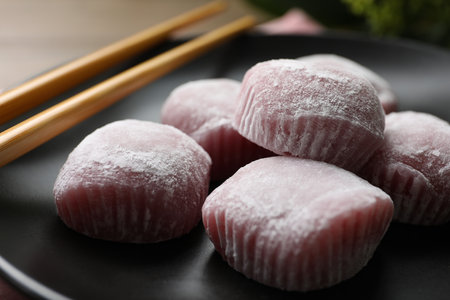 Delicious mochi and chopsticks on black plate, closeup. Traditional Japanese dessertの写真素材