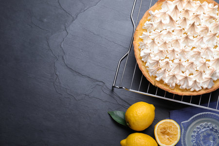 Flat lay composition with delicious lemon meringue pie on black table. Space for textの写真素材