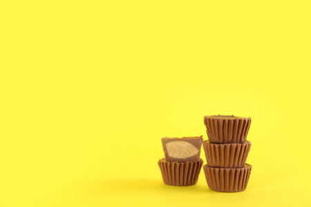 Sweet peanut butter cups on yellow background. Space for textの写真素材