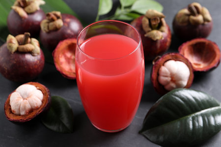 Delicious mangosteen juice in glass on dark tableの写真素材