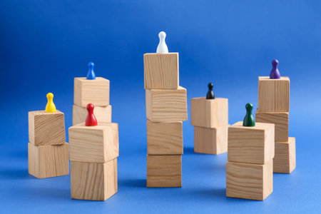 Wooden blocks with color playing pieces on blue background. Roles and responsibilities concept