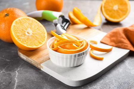 Orange fruits with peel on gray marble tableの写真素材