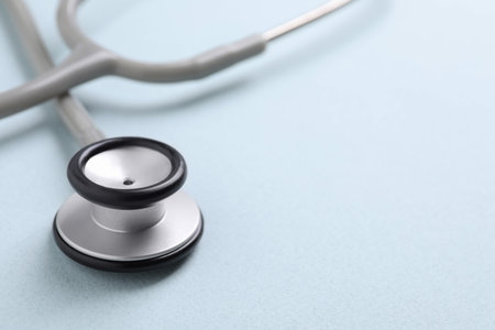 Stethoscope on light blue background, closeup. Space for textの写真素材