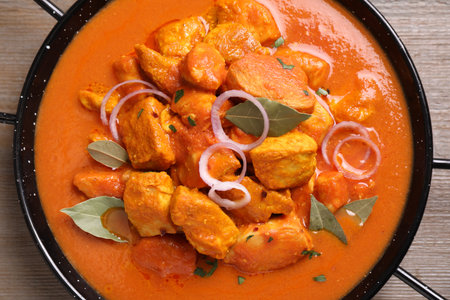 Delicious chicken curry in pan on wooden table, top viewの写真素材