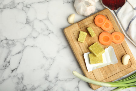 Bouillon cubes and other ingredients on white marble table, flat lay. Space for textの写真素材