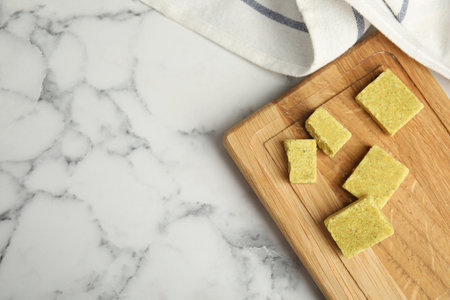 Bouillon cubes with wooden board on white marble table, top view. Space for textの写真素材