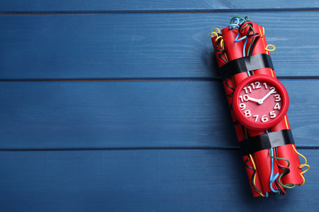 Dynamite time bomb on blue wooden table, top view. Space for textの写真素材