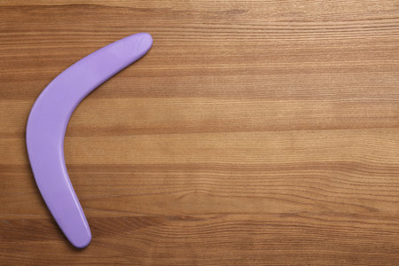 Boomerang on wooden background, top view. Space for textの写真素材