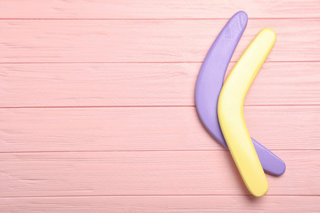 Boomerangs on pink wooden background, flat lay. Space for textの写真素材