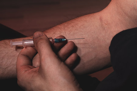 Man taking drugs on dark background, closeup