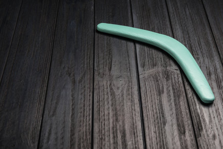 Boomerang on black wooden background. Space for textの写真素材