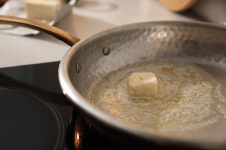 Frying pan with melted butter on stove, closeupの写真素材