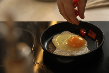 Man cooking egg in small frying pan, closeupの写真素材