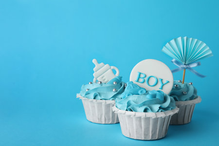 Baby shower cupcakes with toppers on light blue background, space for textの写真素材