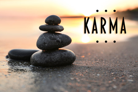 Karma concept. Stones on sand near the sea at sunsetの写真素材