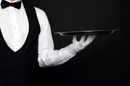 Butler with tray on black background, closeupの写真素材