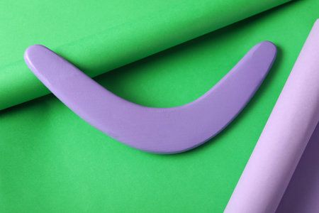 Lilac wooden boomerang on green background. outdoor activitiesの写真素材