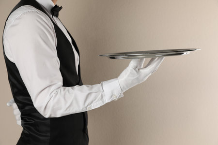 Butler with tray on beige background, closeupの写真素材