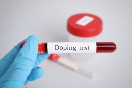 Doctor holding test tube with blood sample over table, closeup. doping controlの写真素材