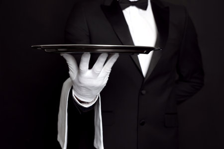 Butler with tray on black background, closeupの写真素材