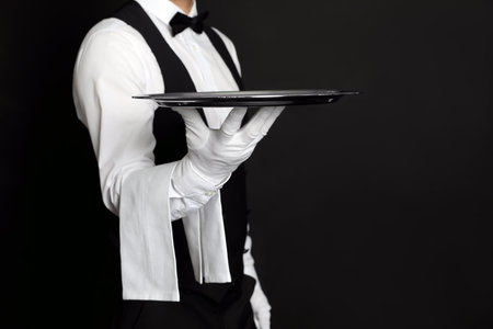 Butler with tray on black background, closeupの写真素材